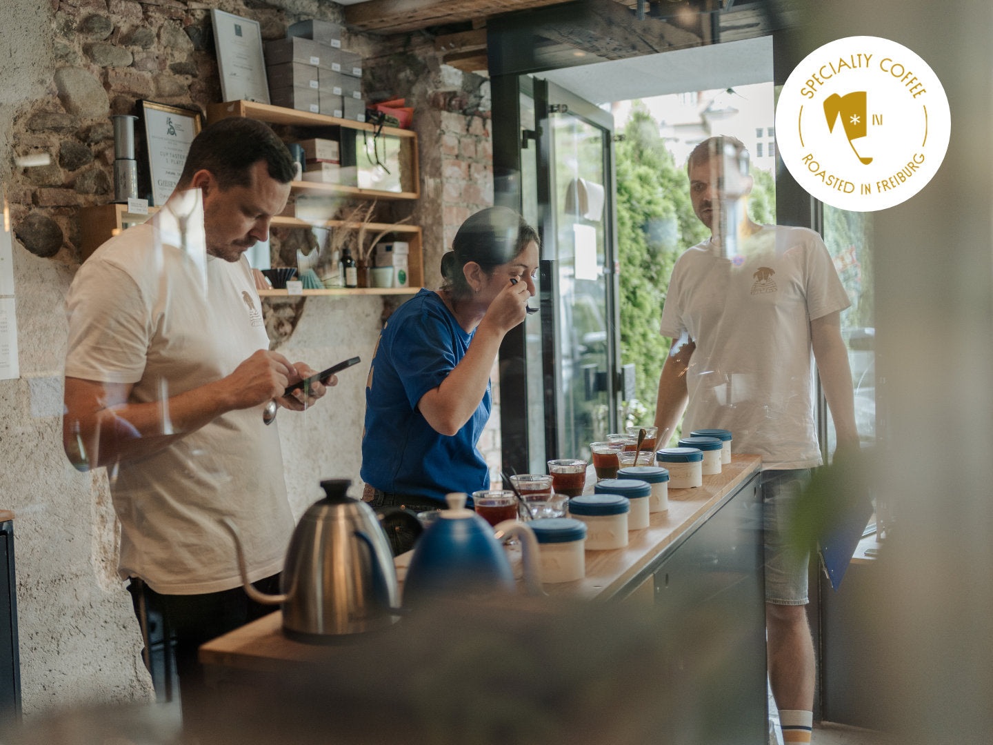 Titelbild zum Blogartikel über Coffee Cupping. Philip, Aurore und Mats cuppen Kaffees.