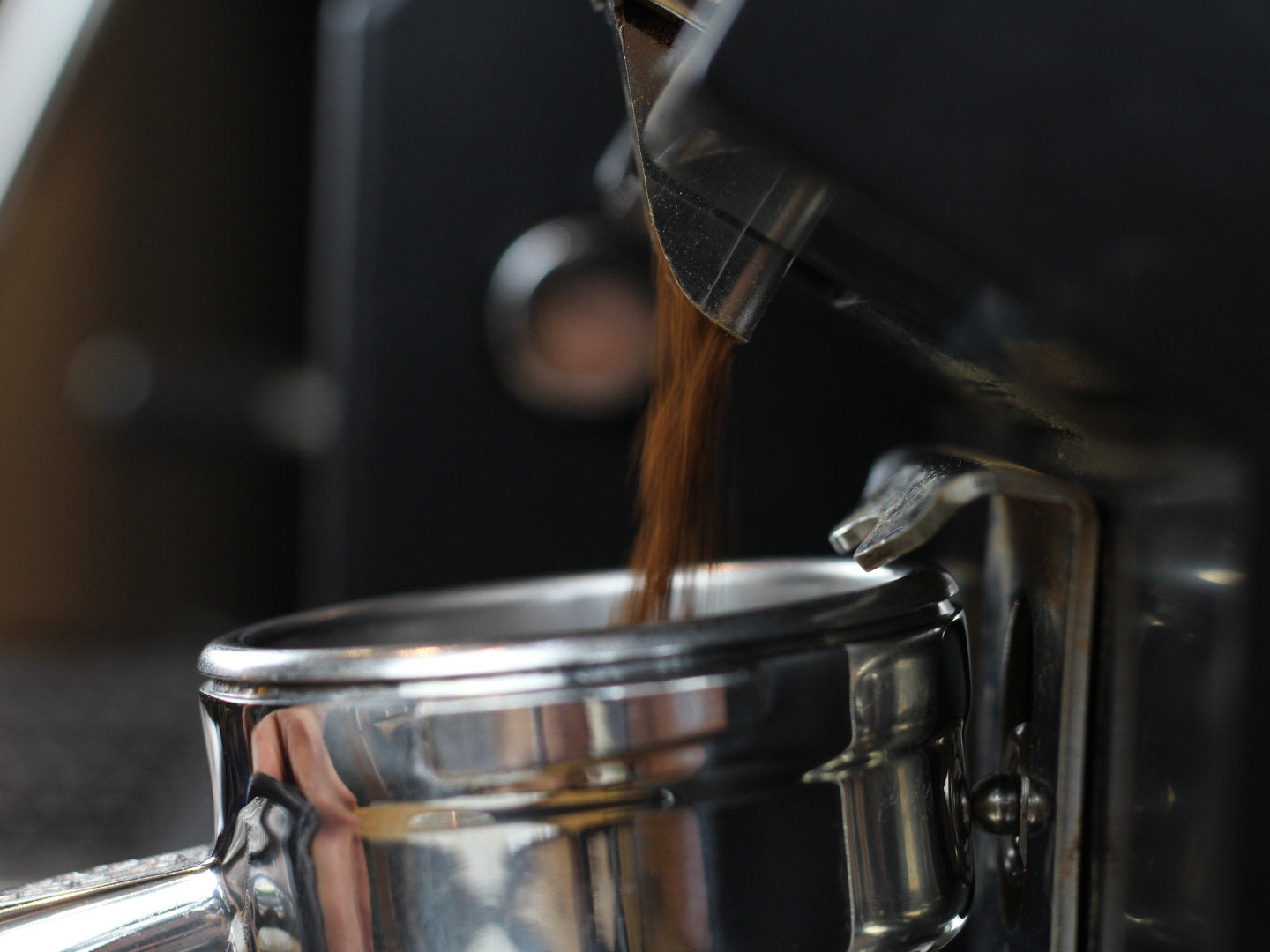 Titelbild zum Blogartikel über das Dial-in für Espressomühlen. Zu sehen ist, wie Kaffeemehl in einen Siebträger gleitet.