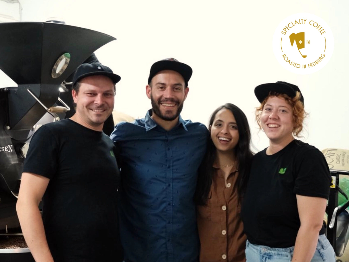 Titelbild zum Blogartikel über Nikolai Fürst. Zu sehen sind Philip Weller, Nikolai Fürst, Manuela Vásquez und Sandy Gruhle in der Rösterei der Günter Coffee Roasters.