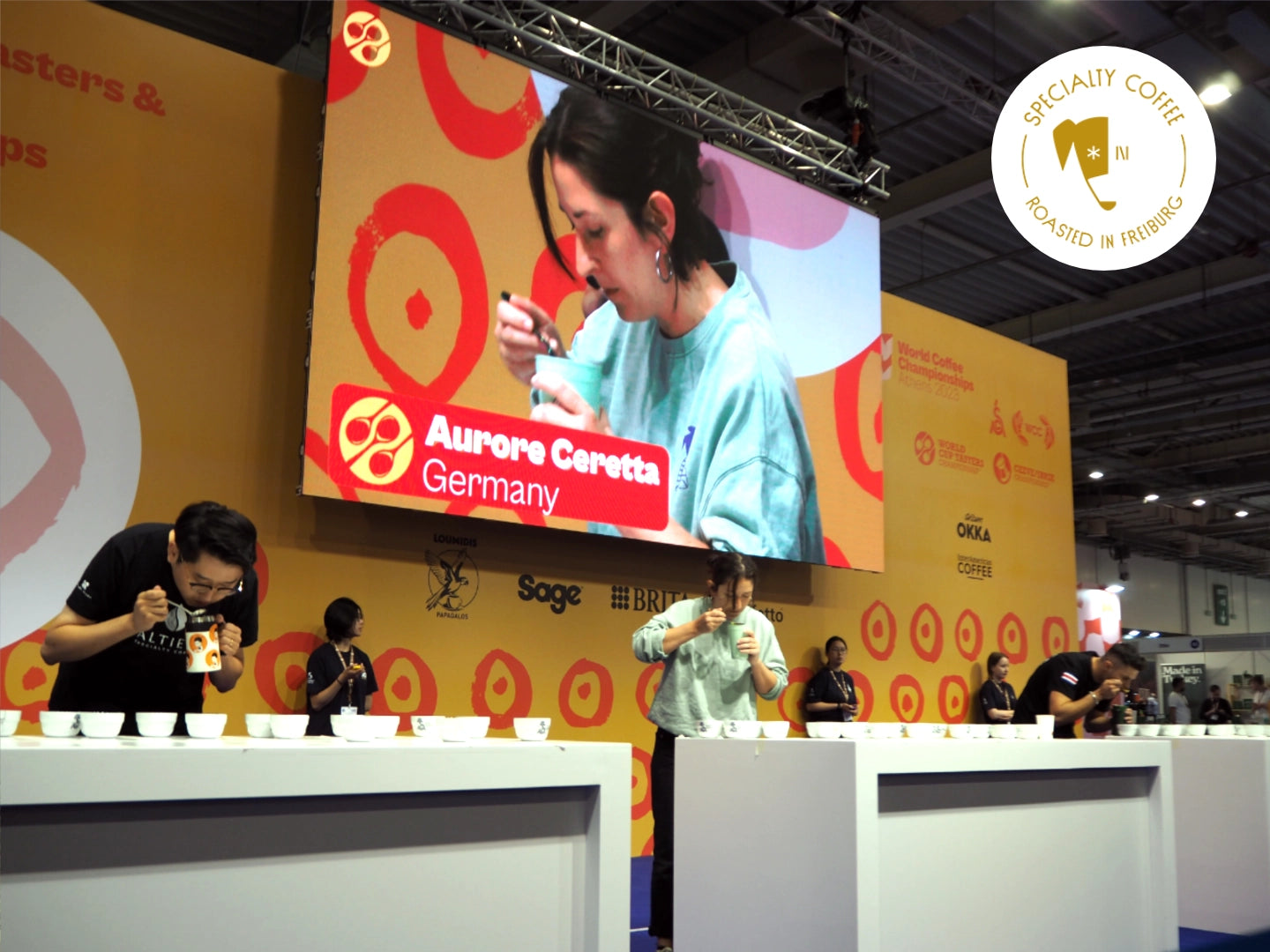 Titelbild zum Blogartikel über die World Coffee Championships. Zu sehen ist Inhaberin der Günter Coffee Roasters Aurore Ceretta bei ihrem Auftritt bei den World Cup Tasters Championships.