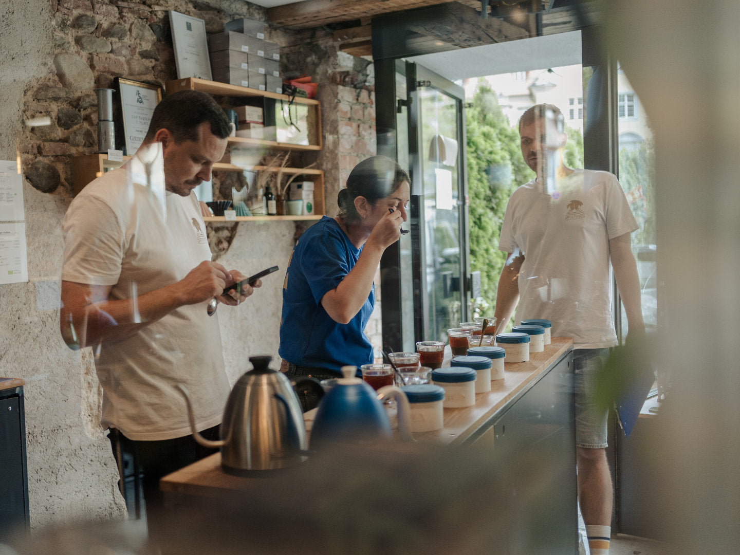 Titelbild zum Blogartikel über Coffee Cupping. Philip, Aurore und Mats cuppen Kaffees.