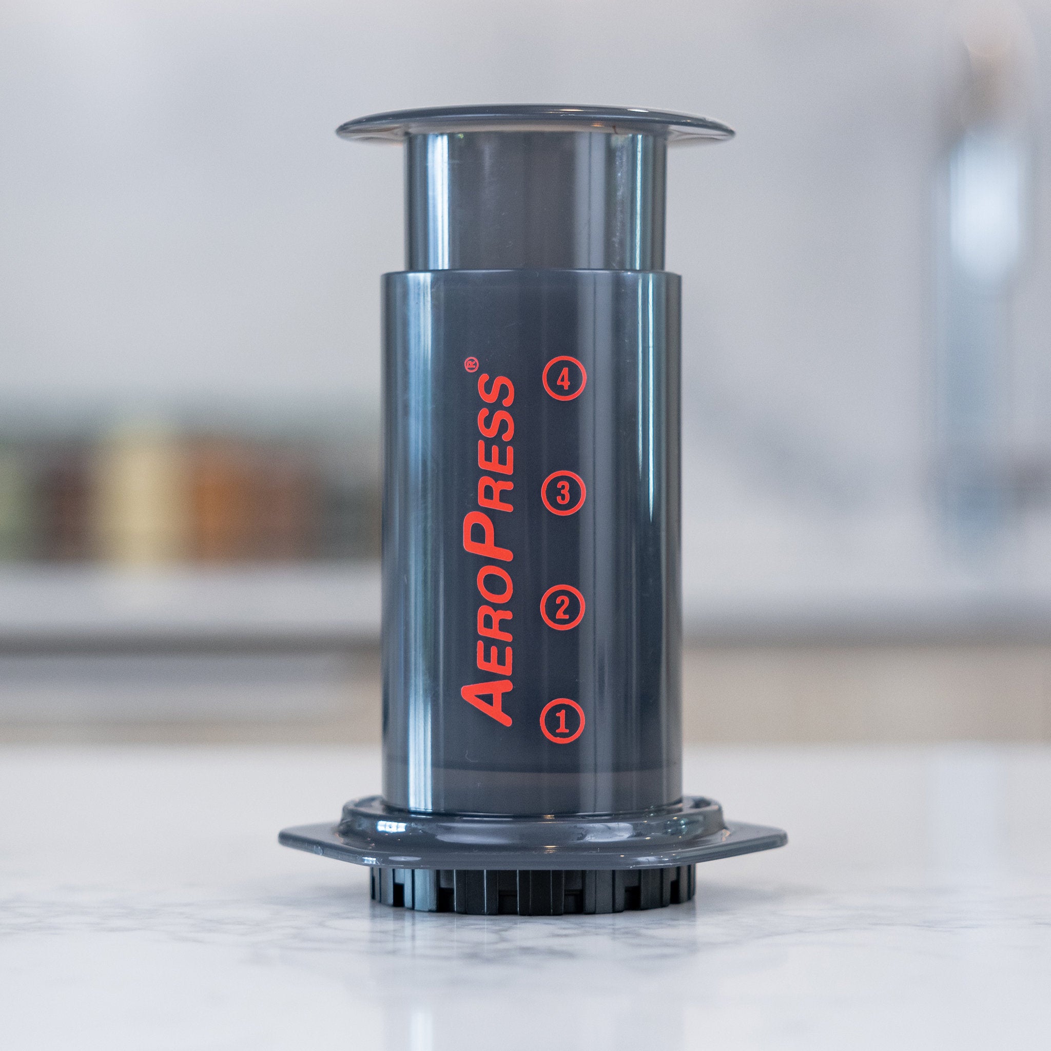 AeroPress Kaffeebereiter Edition 2023 aus Polypropylen mit roter Beschriftung auf einer Steinplatte.