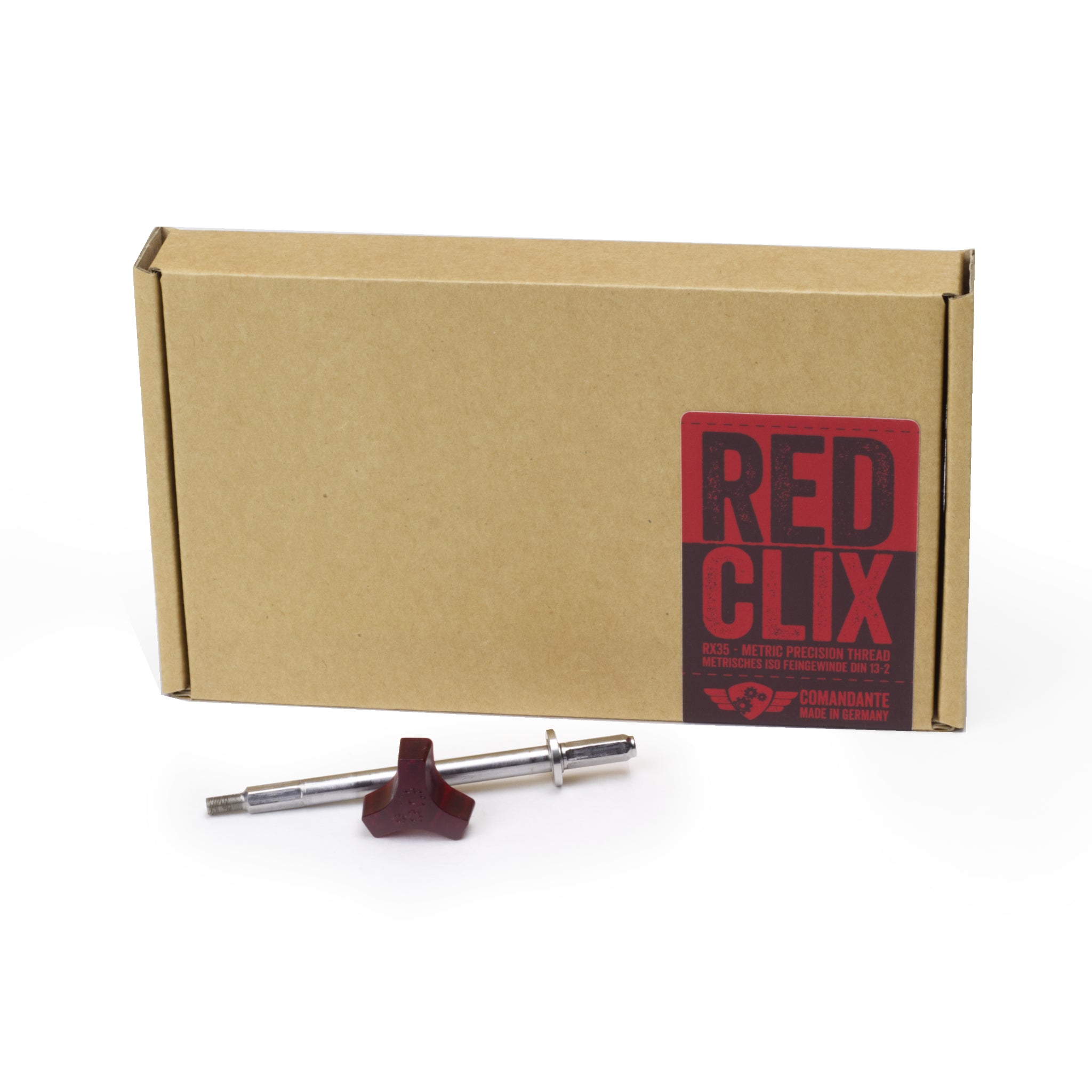 Bild der Wettbewerbsachse Red Clix RX35 für die Comandante C40 Kaffeemühle. Die Achse liegt vor der braunen Produktverpackung mit rot/schwarzem Aufkleber.